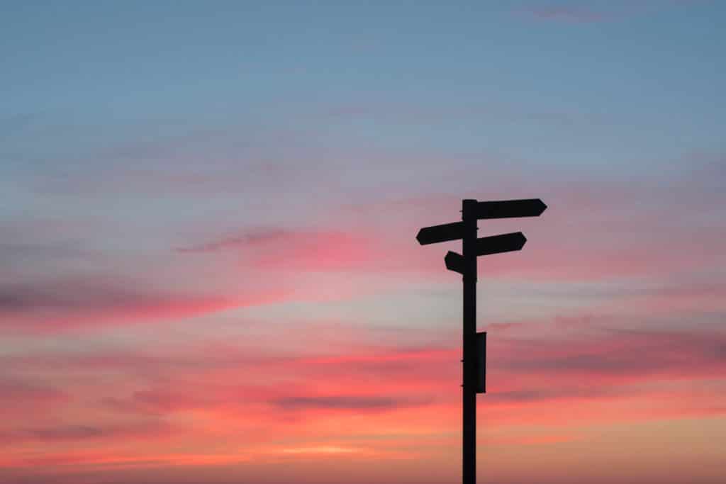 Coucher de soleil avec panneau de direction en ombre chinoise